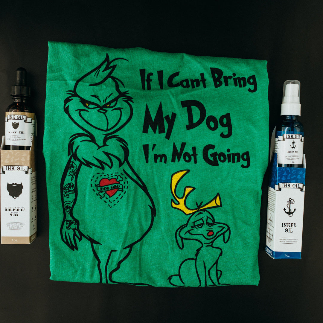 Green t-shirt with cartoon character and text, surrounded by two bottles on a dark background